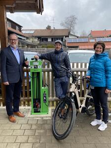 Bild vergrößern: Bürgermeister Christoph Schmid (l.) freut sich über die Radservice-Station, die ihm Tim Coldewey von der REO und Klimaschutz-Managerin Antonia Rüede-Passul überreichten.